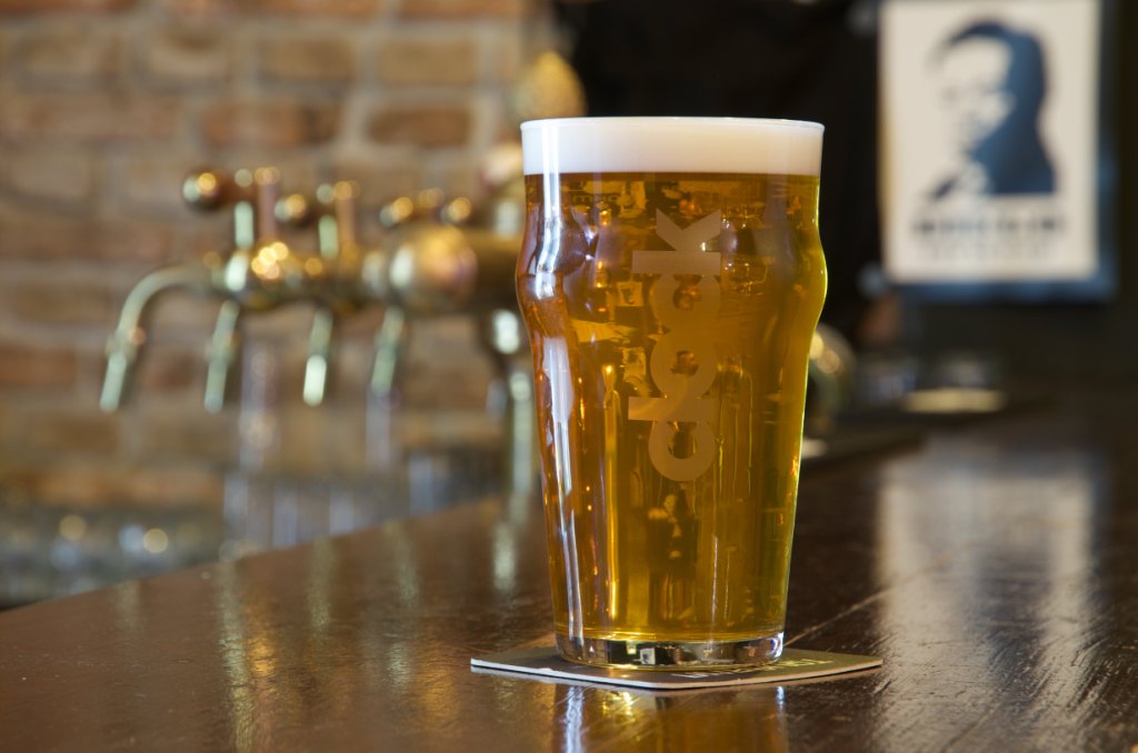 Pohled na pivo v půllitru značky Clock a výčepní zařízení v pozadí