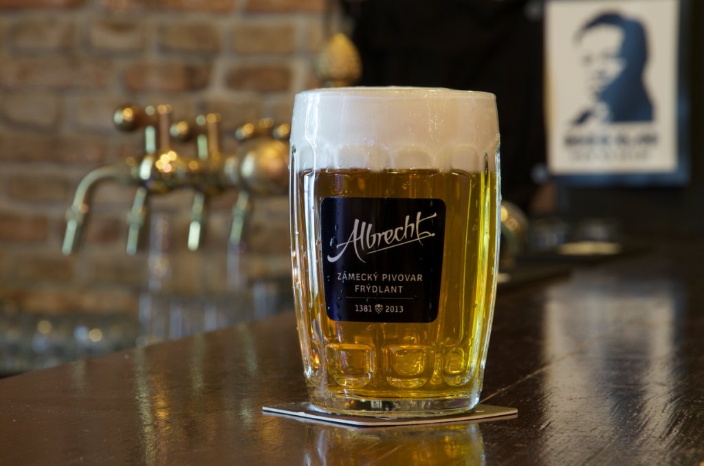 Pivo albrecht v skleněném půllitru a v pozadí výčepní zařízení